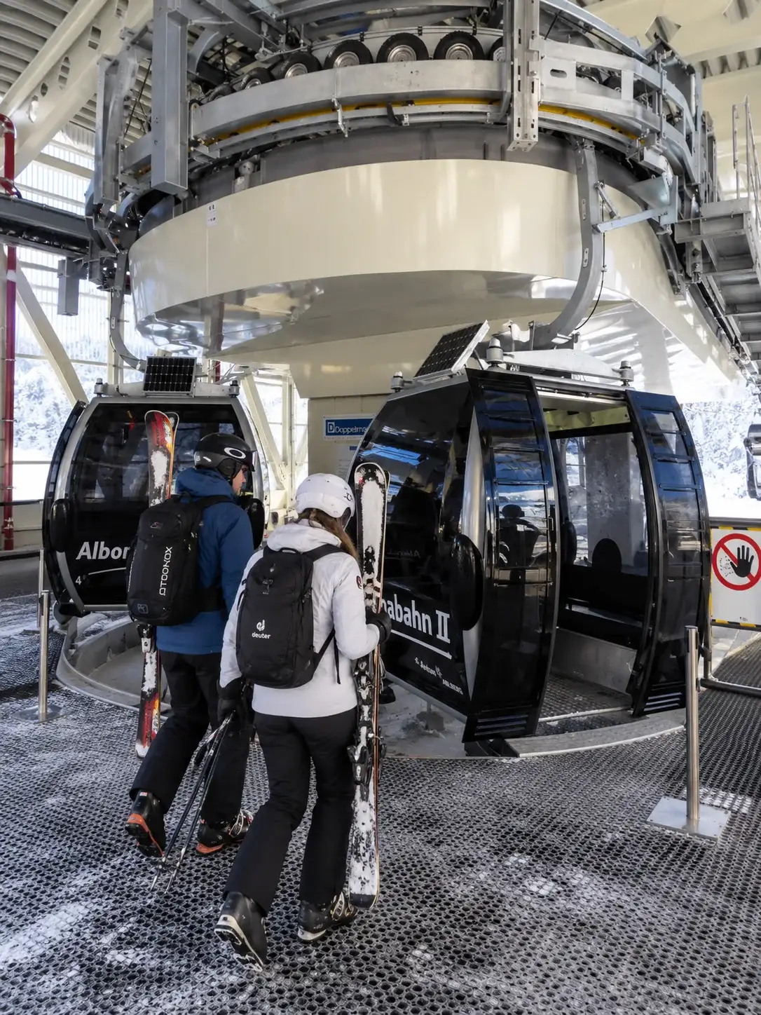 Skifahren in Stuben am Arlberg und auf der Albona Skifahrer steigen in die Gondel der Albonabahn II über Stuben am Arlberg ein